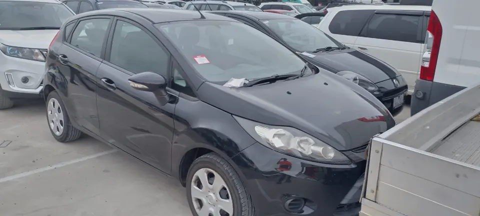 Grey hatchback beside a utility vehicle