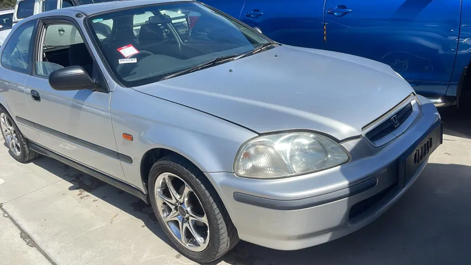 Silver coupe parked in a vehicle yard