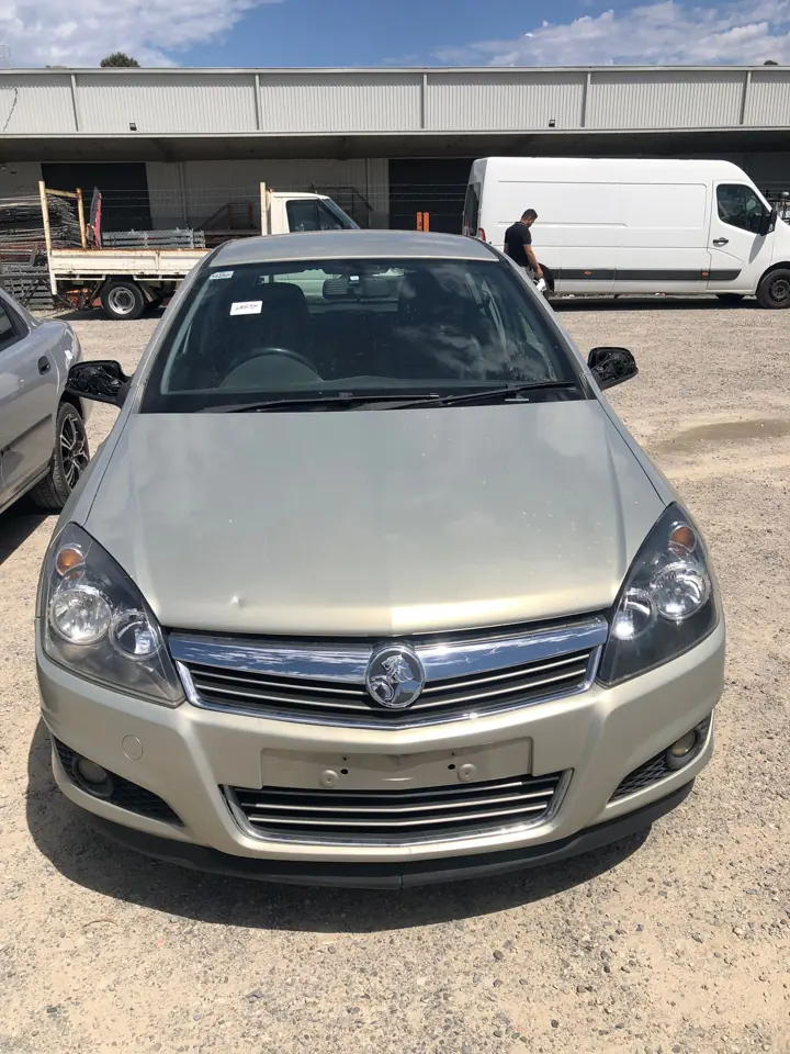 Light-coloured hatchback beside other cars