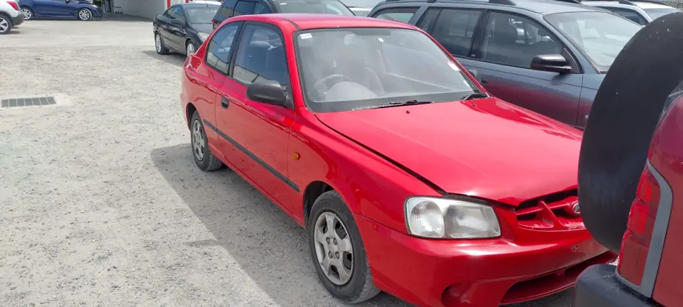 Red compact hatchback in a vehicle yard