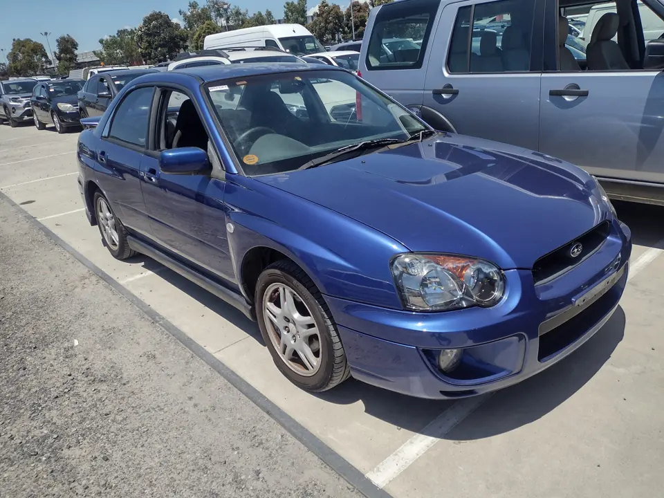 Blue sedan in an outdoor vehicle yard