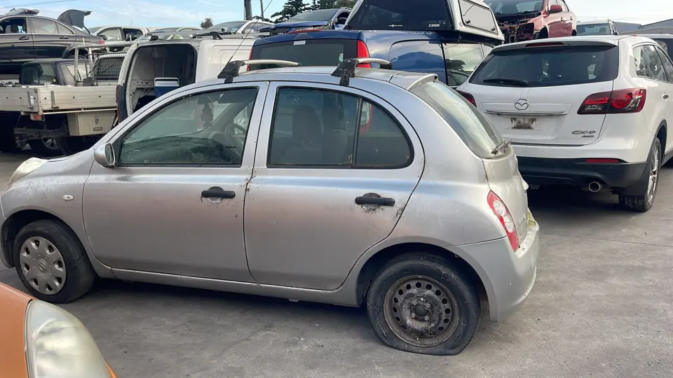 Silver compact hatchback in a yard