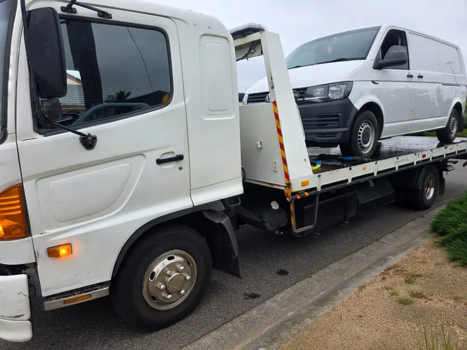 White van loaded on a truck