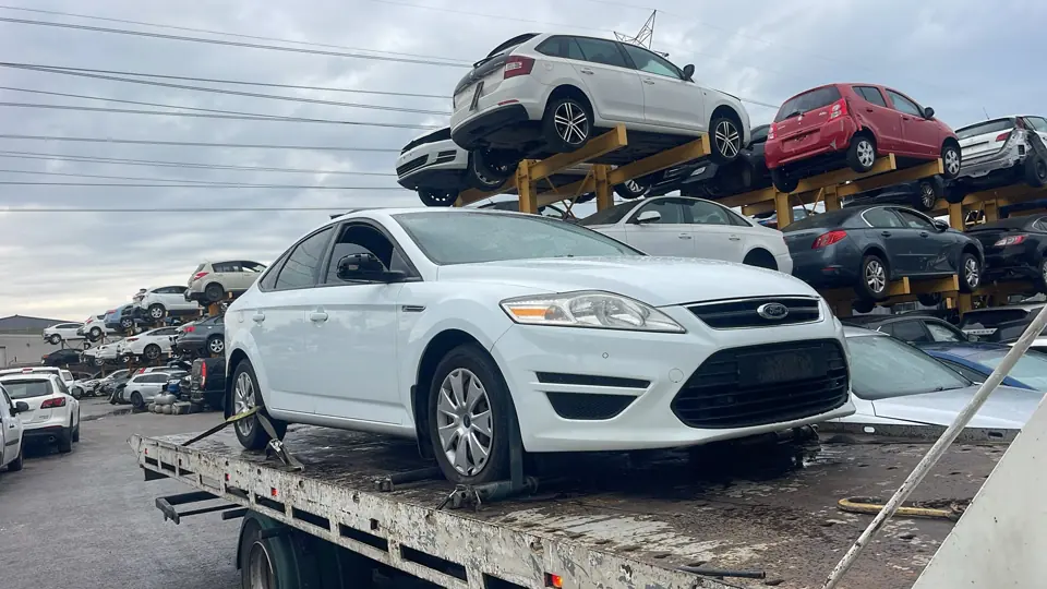 White sedan among parked vehicles