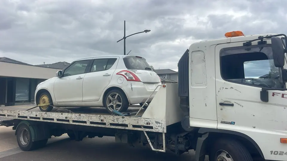 White vehicle carried on a truck
