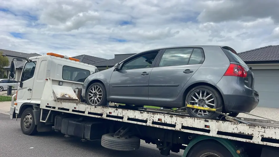 Silver hatchback on a recovery truck