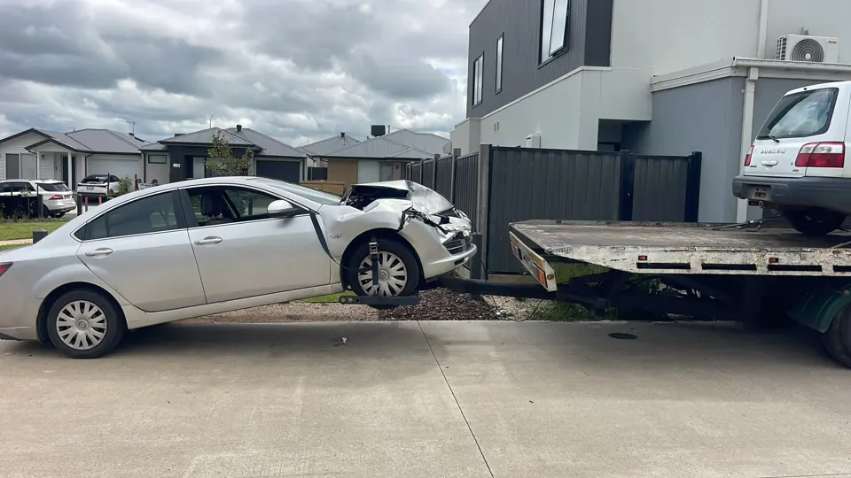 Silver sedan beside a recovery truck